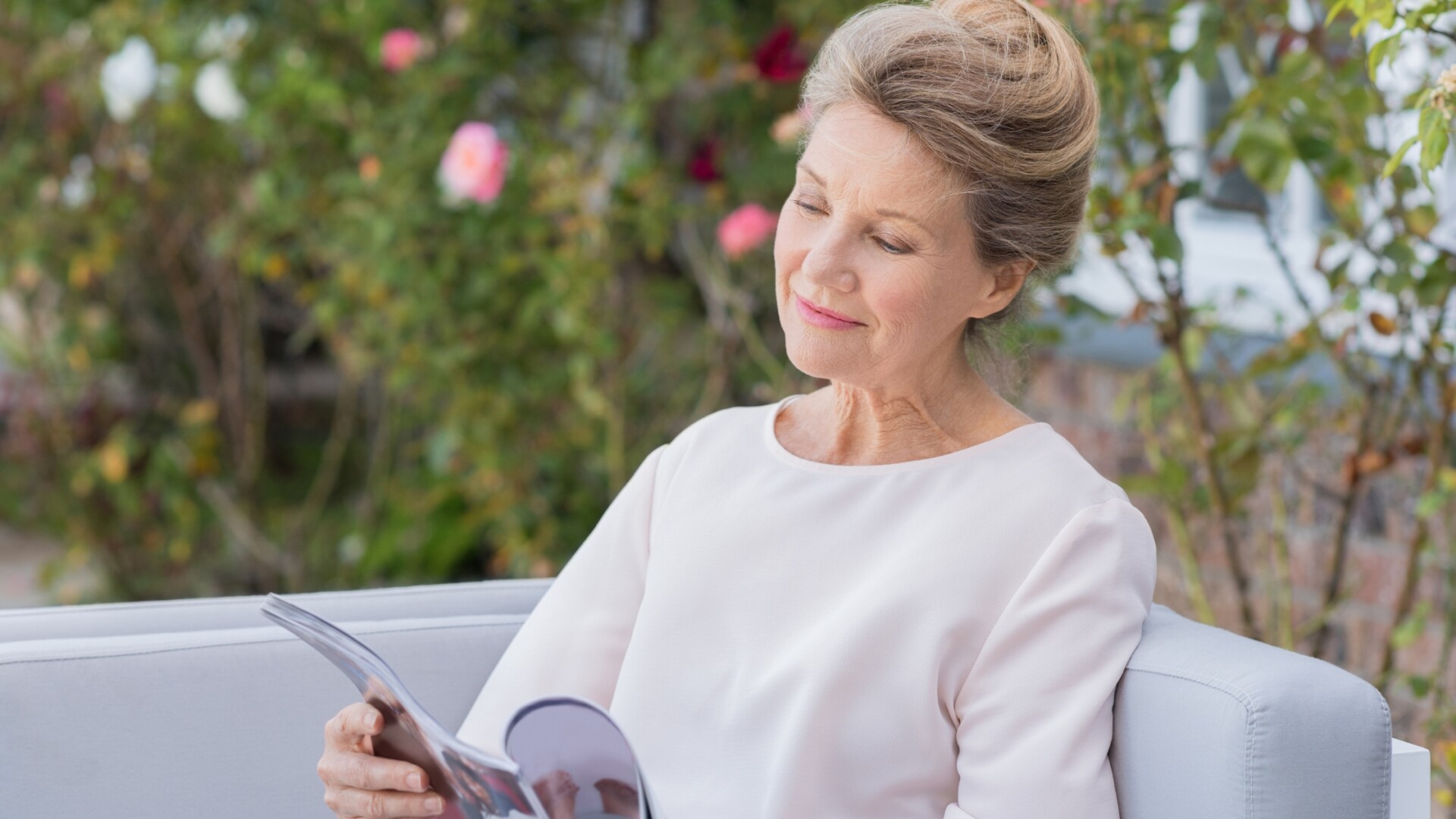 Woman reading a magazine outdoors, enjoying a calm and mindful moment